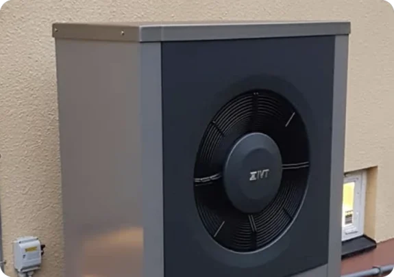 Närbild på fläkten och skyddsgallret på en modern luftvärmepump.